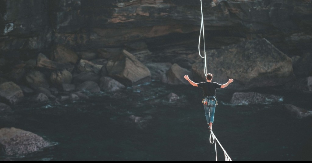 man balancerend op koord